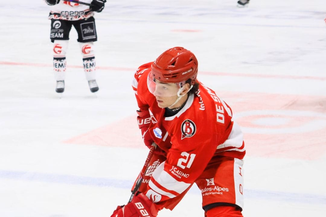 Sacha De Smitt, n° 21 des Diables Rouges, en maillot rouge, le palet devant la crosse sur la glace