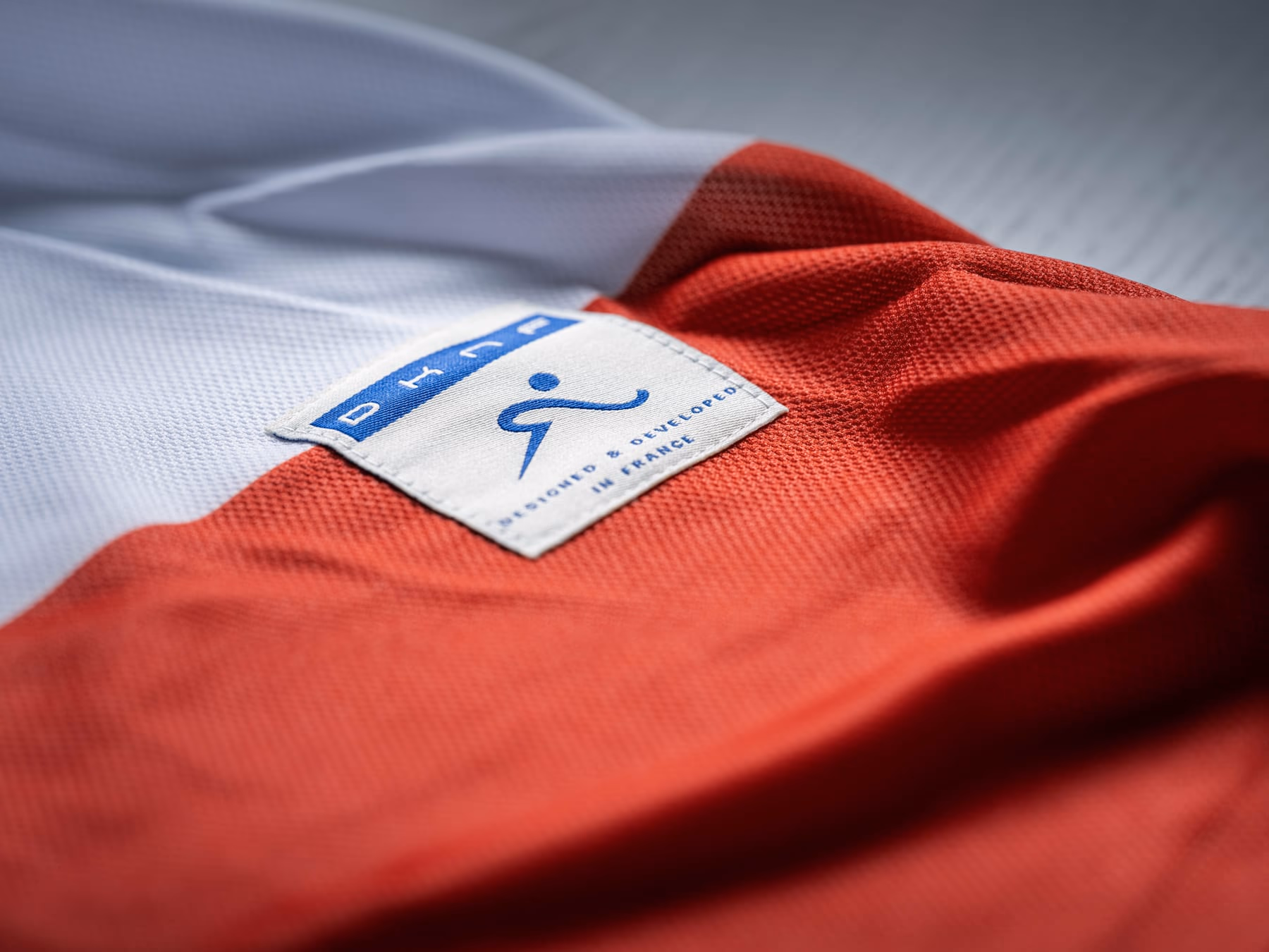 Détail du maillot de pré-saison des Diables Rouges, blanc et rouge, avec son étiquette