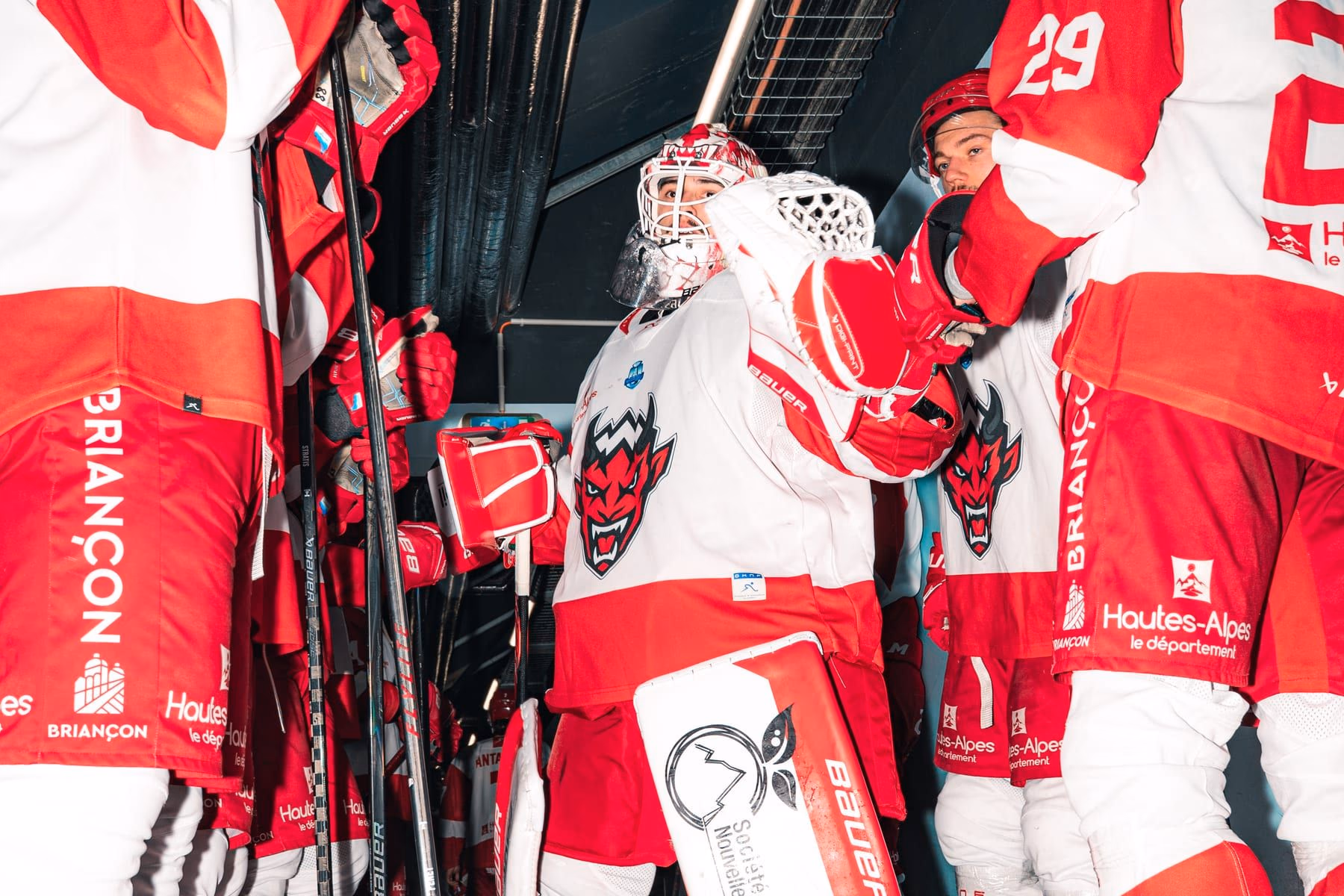 Le gardien des Diables Rouges entouré de ses coéquipiers dans le tunnel avant d'entrer sur la glace